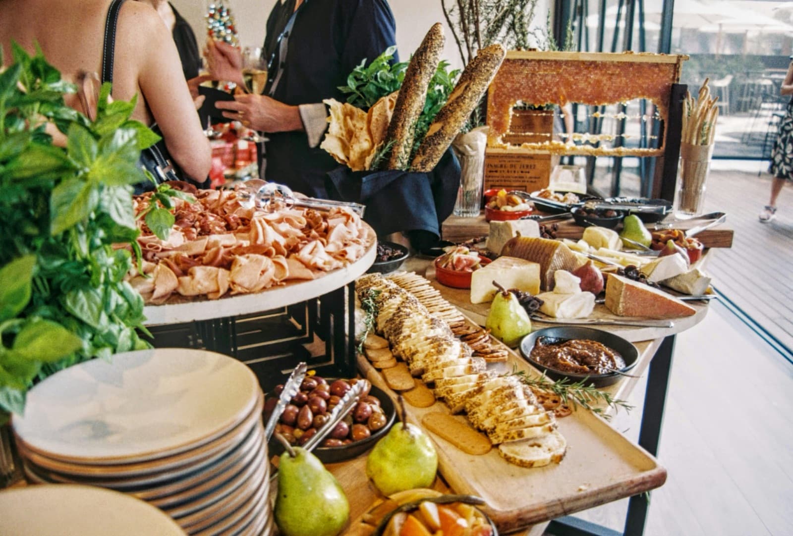 Ein Buffet mit Aufschnitt, Käse, Brot, Oliven und Birnen
