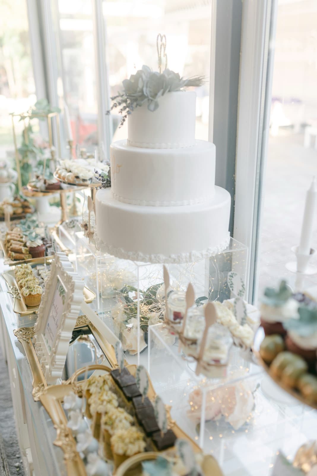 Eine Hochzeitstorte mit kleinen Süßigkeiten auf dem Tisch davor