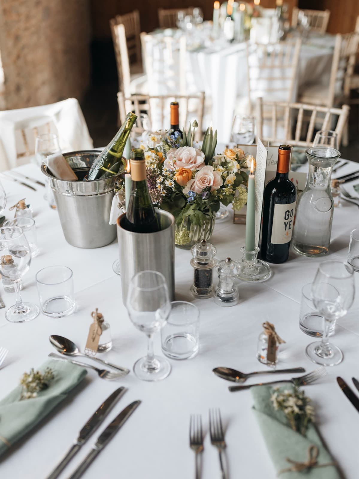 Ein runder Tisch mit Blumenstrauß, Wein und Kerzen